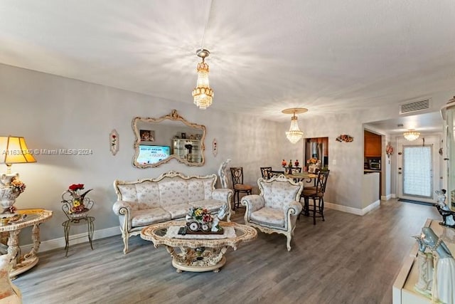 living room featuring visible vents, baseboards, and wood finished floors