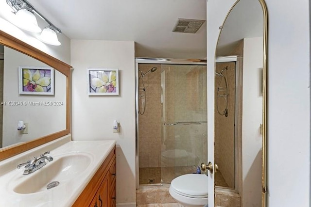 bathroom with toilet, a shower stall, and visible vents