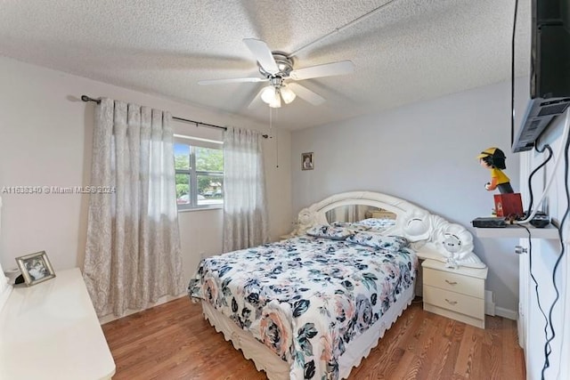 bedroom with a textured ceiling, ceiling fan, and light wood-style floors