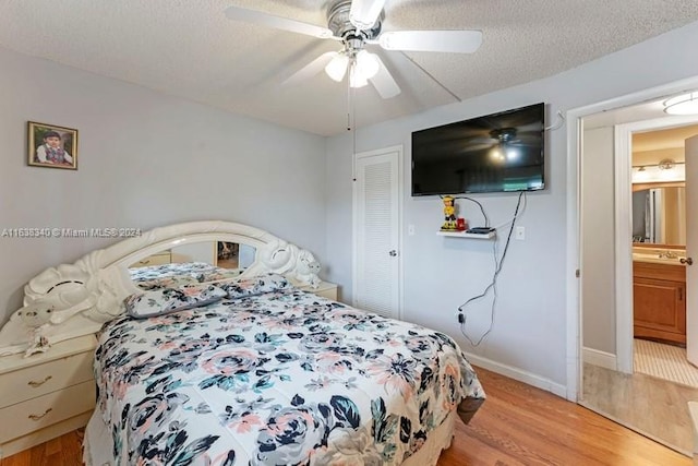 bedroom featuring a closet, baseboards, a textured ceiling, and light wood finished floors