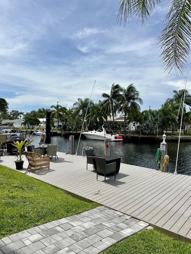 view of dock with a water view and a yard