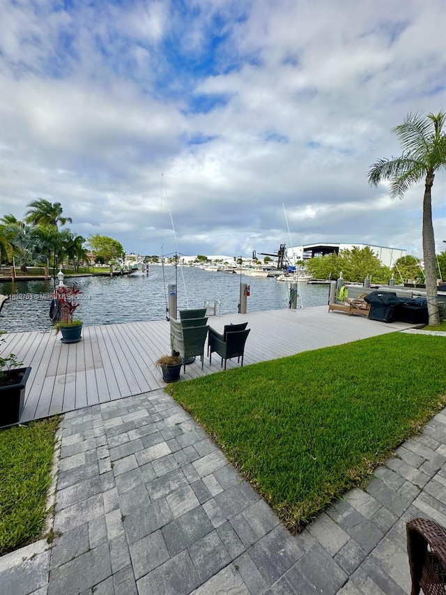 view of dock with a yard and a water view