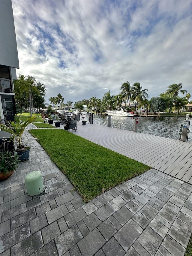 exterior space featuring a water view, a dock, and a patio