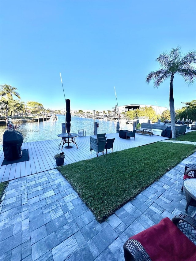 view of dock featuring a lawn and a water view