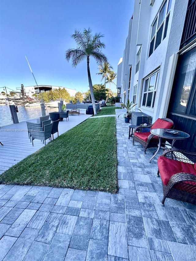 view of home's community featuring a yard, a water view, and a patio