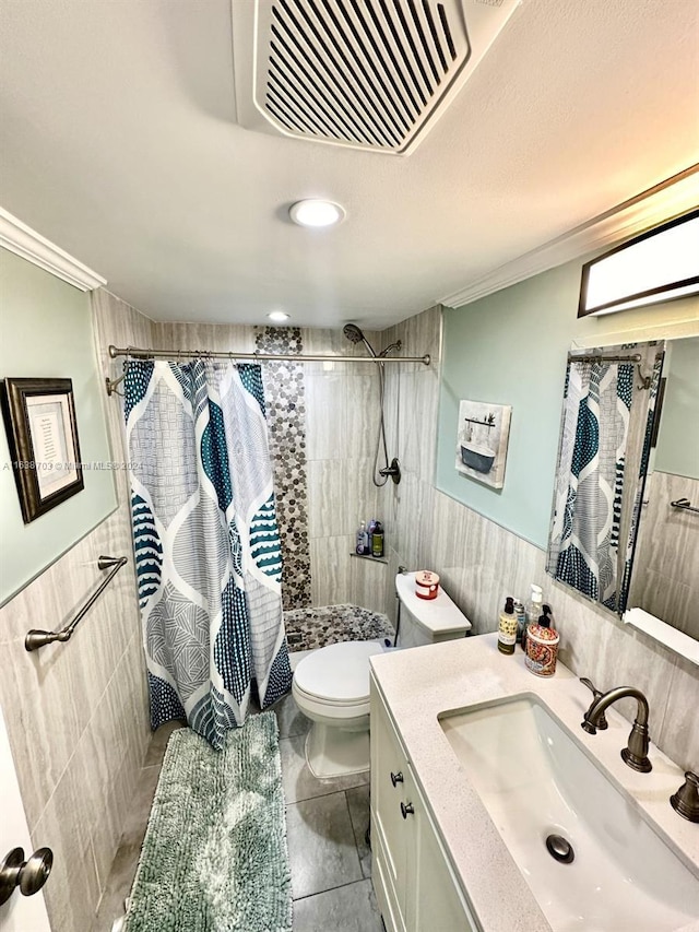 bathroom with a shower with curtain, toilet, vanity, tile walls, and ornamental molding