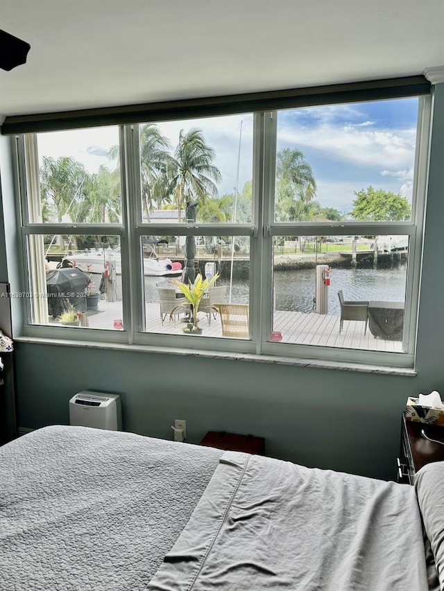 bedroom featuring multiple windows and a water view