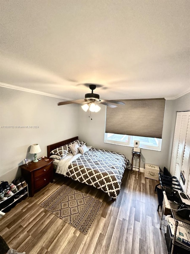 bedroom with hardwood / wood-style floors, a closet, ceiling fan, and ornamental molding