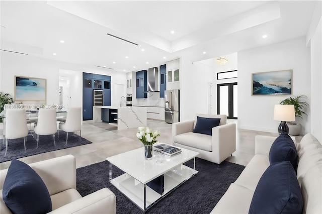 tiled living room featuring a raised ceiling