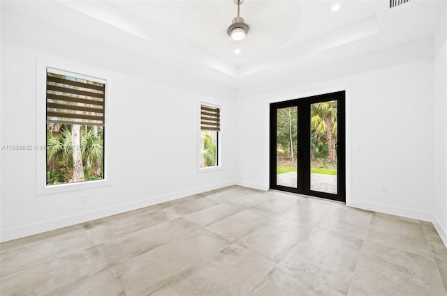 unfurnished room featuring ceiling fan, light tile patterned flooring, a raised ceiling, and french doors