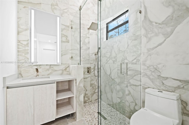 bathroom with a shower with shower door, vanity, tile walls, and toilet