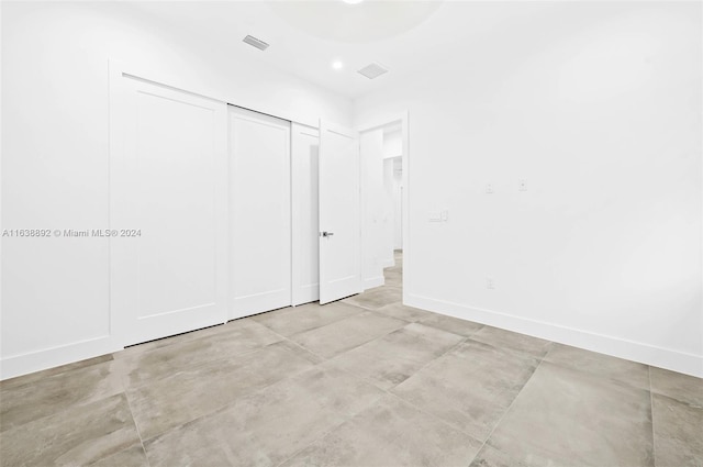 unfurnished bedroom with light tile patterned floors and a closet