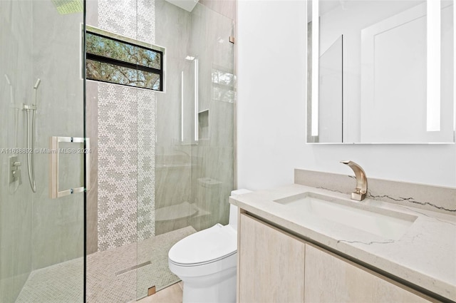 bathroom with a shower with shower door, vanity, and toilet