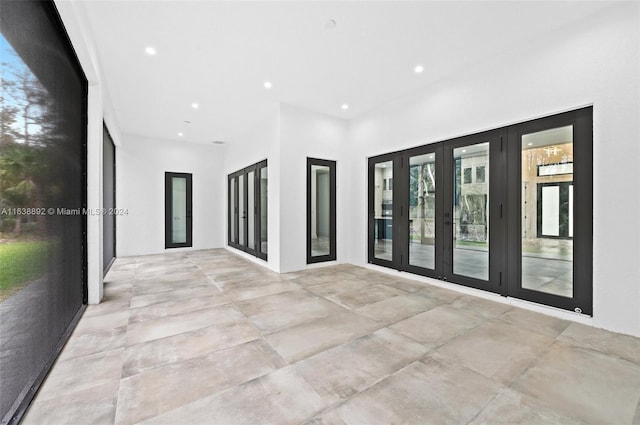 unfurnished room with light tile patterned flooring and french doors