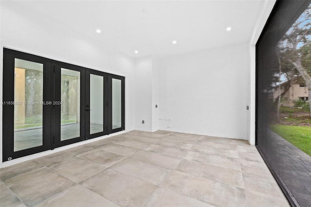 unfurnished room featuring light tile patterned flooring and french doors