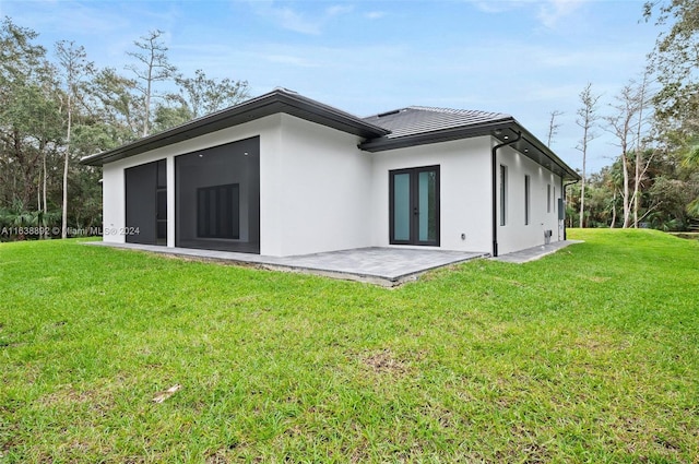 rear view of house with a patio and a yard