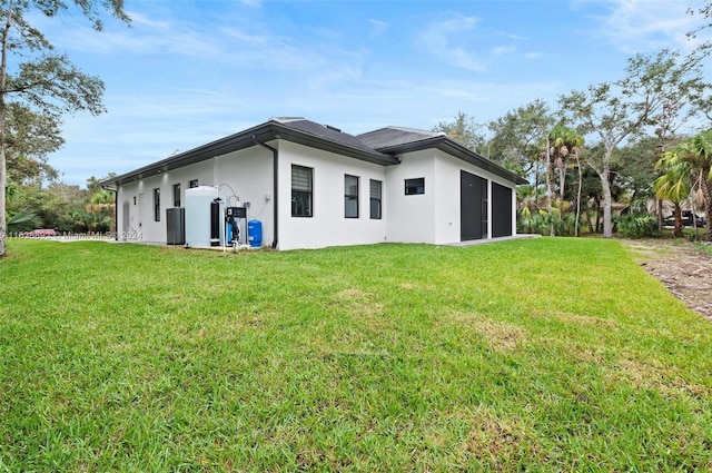 rear view of property featuring a lawn