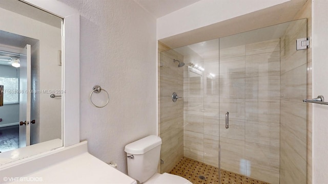 bathroom featuring toilet, an enclosed shower, and ceiling fan