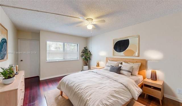 bedroom with ceiling fan, a textured ceiling, and dark hardwood / wood-style flooring