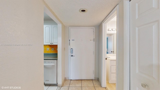 hallway with light tile patterned flooring and a textured ceiling