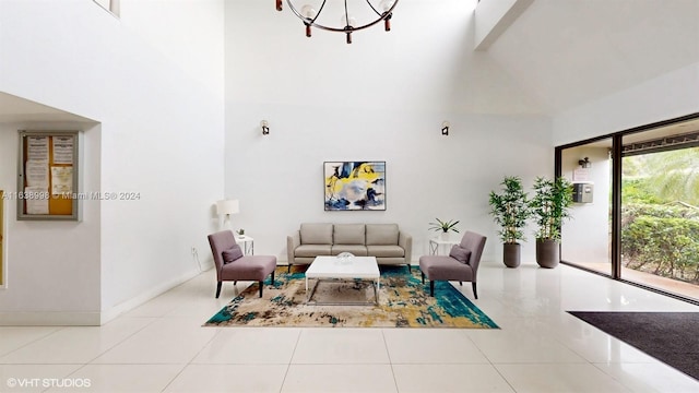 tiled living room with a high ceiling and an inviting chandelier