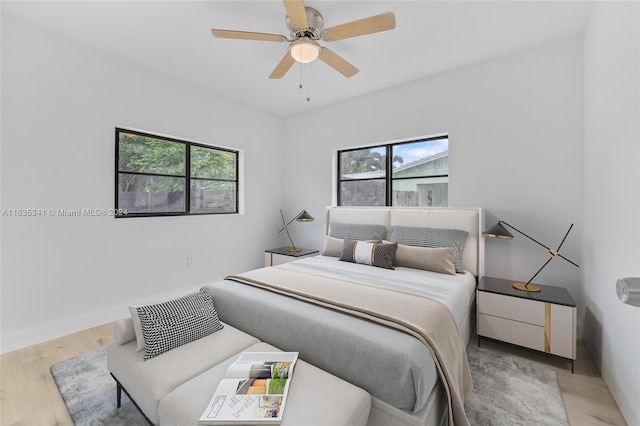 bedroom featuring multiple windows, ceiling fan, and light hardwood / wood-style flooring