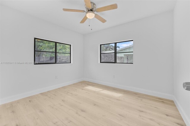 empty room featuring a healthy amount of sunlight, ceiling fan, and light hardwood / wood-style floors