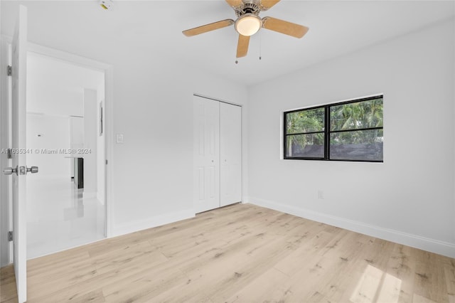 unfurnished bedroom featuring light hardwood / wood-style flooring, ceiling fan, and a closet