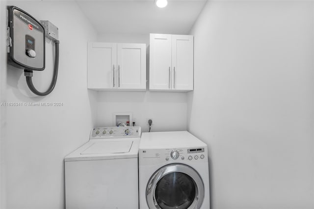 clothes washing area with cabinets and washing machine and dryer