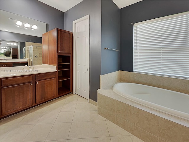 bathroom with tile patterned floors, tiled bath, and vanity