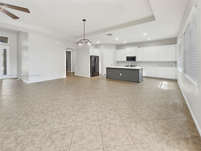 unfurnished living room featuring ceiling fan, light tile patterned flooring, and sink