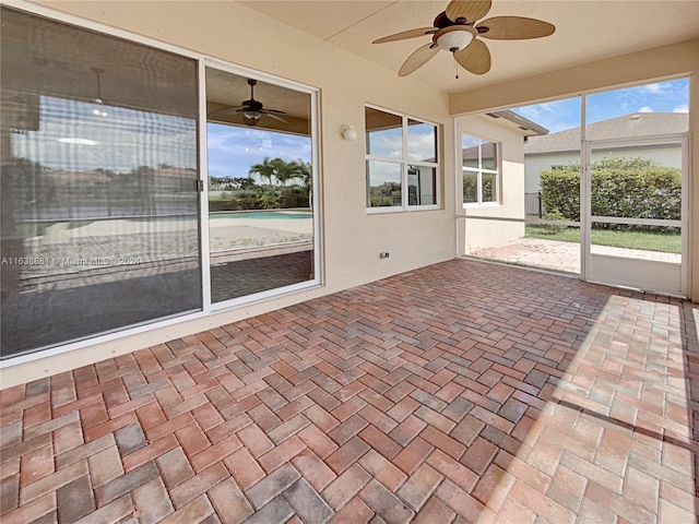 unfurnished sunroom featuring ceiling fan