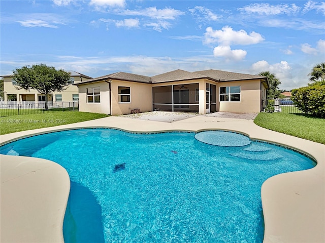 view of pool with a sunroom and a lawn