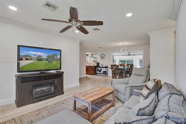 living room with ceiling fan with notable chandelier, light wood-type flooring, and ornamental molding