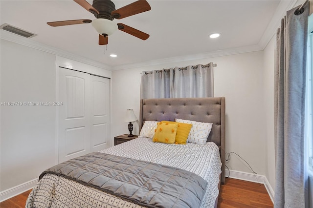 bedroom featuring ornamental molding, dark hardwood / wood-style flooring, ceiling fan, and a closet