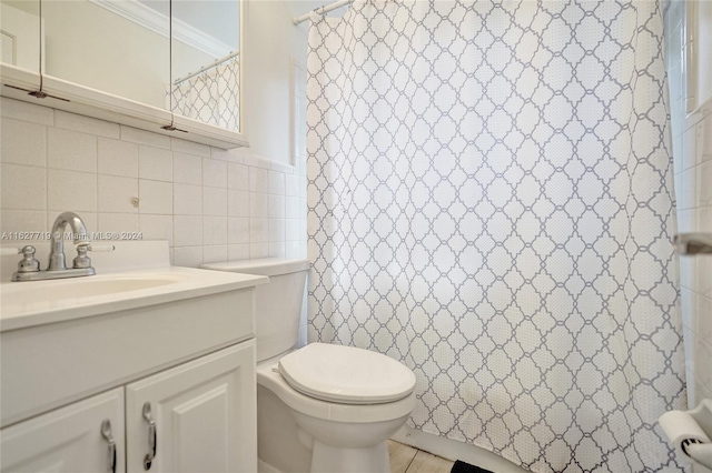 bathroom with vanity, tile walls, crown molding, and toilet