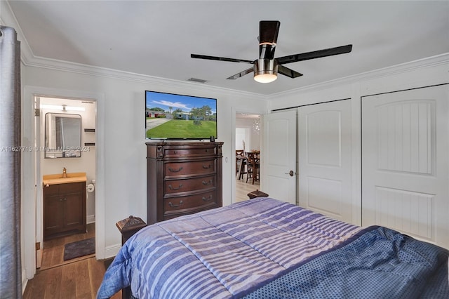 bedroom with ceiling fan, sink, crown molding, ensuite bath, and hardwood / wood-style floors