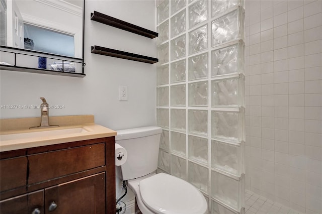 bathroom with vanity, toilet, and tiled shower