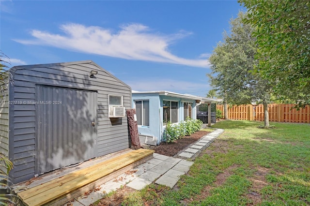 exterior space featuring a lawn, cooling unit, and a storage shed