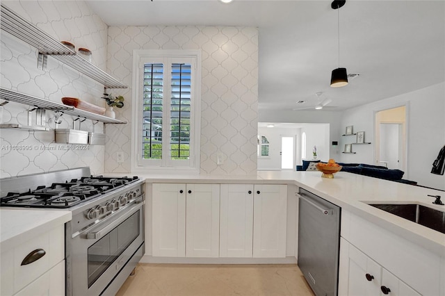 kitchen with light tile patterned flooring, appliances with stainless steel finishes, hanging light fixtures, white cabinets, and sink