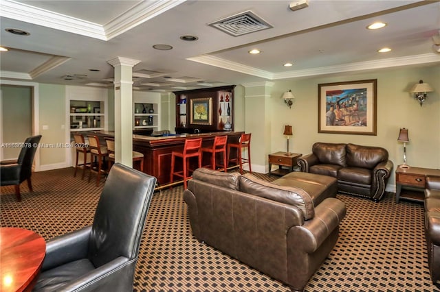 carpeted living room with ornate columns, crown molding, bar, and built in shelves