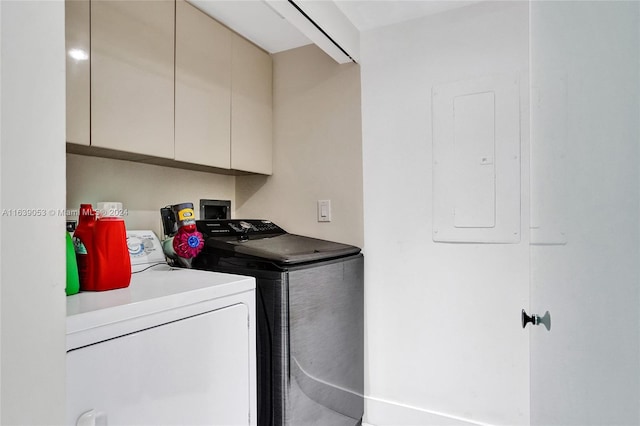 clothes washing area featuring electric panel, separate washer and dryer, and cabinets