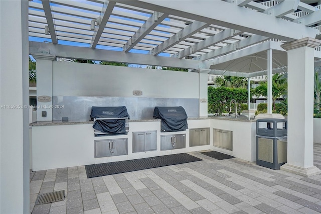 view of patio with an outdoor kitchen, a grill, and a pergola