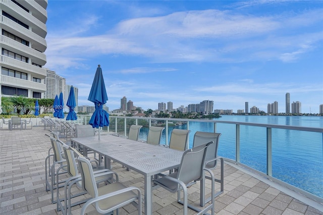 view of patio featuring a water view and a balcony