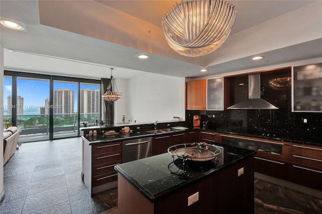 kitchen featuring tasteful backsplash, wall chimney range hood, sink, a center island, and stainless steel dishwasher