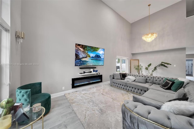 living room featuring wood-type flooring, an inviting chandelier, and high vaulted ceiling