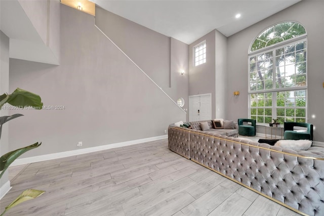 living room with a high ceiling and light hardwood / wood-style flooring