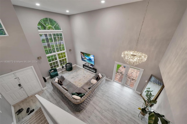 living room featuring a high ceiling, hardwood / wood-style floors, and an inviting chandelier