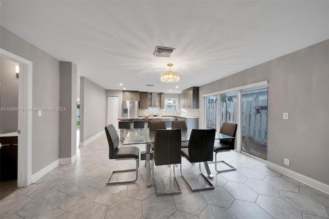 tiled dining space featuring an inviting chandelier