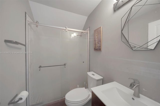 bathroom with an enclosed shower, vanity, toilet, and vaulted ceiling